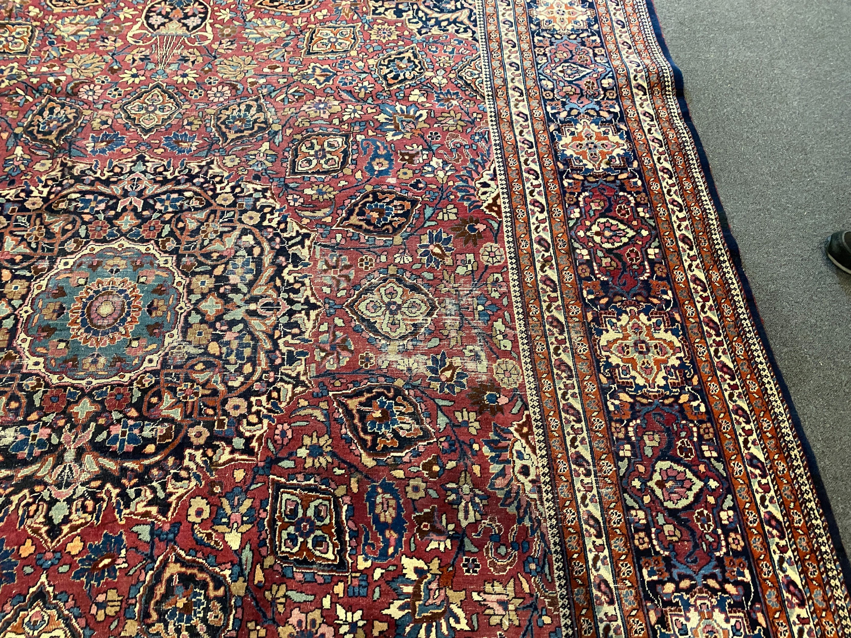 An early 20th century Heriz burgundy ground carpet, 412 x 305cm